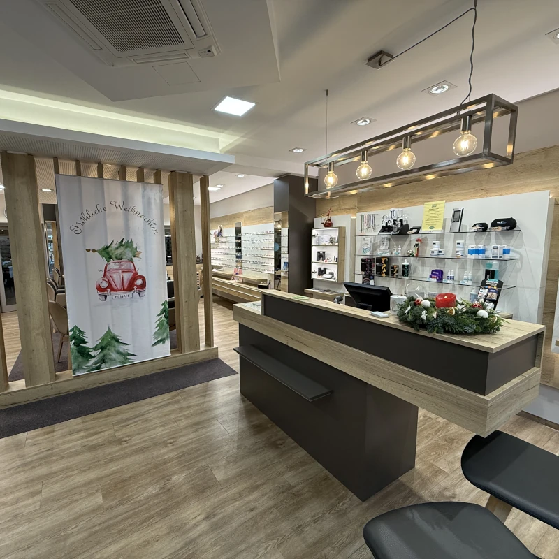 Innenansicht des Optikgeschäfts Kossack e.K. in Calau mit modernem Verkaufsraum, großzügiger Brillenauswahl und einladendem Empfangsbereich.